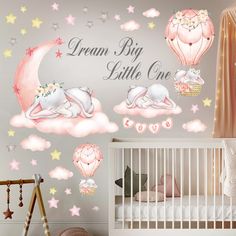 a baby's nursery room with pink and white wallpaper, stars and hot air balloons