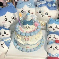 a group of stuffed animals sitting next to a cake