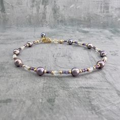 "✦This handmade beaded pearl and seed bead bracelet is made with gorgeous lavender purple round freshwater pearls and matching purple glass dainty seed beads. The pearls measure about 4 -5 mm in diameter and the seed beads measure about 2mm in diameter. Gold seed beads and clear Czech glass beads are interspersed with the pearls and seed beads. ✦Delicate and dainty, this bracelet is truly a unique piece to add to your jewelry collection. Makes a great bracelet to wear stacked with your other gol Dainty Purple Beaded Bracelets With Round Beads, Dainty Purple Beaded Bracelet With Round Beads, Dainty Purple Beaded Bracelet, Elegant Purple Beaded Bracelets With Tiny Beads, Purple Beaded Pearl Bracelet, Brazilian Gold, Purple Pearl, Unique Handmade Jewelry, Seed Bead Bracelets