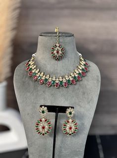 Jiya golden antique Ruby green Kundan Polki Necklace Set with Maangtikka. This Jiya golden antique necklace set features a stunning combination of Ruby green Kundan Polki, complete with a matching Maangtikka. Handcrafted with expert precision, this set exudes timeless elegance and is the perfect addition to any ensemble. Elevate your style with confidence and grace. Green Jeweled Bridal Necklace For Festive Occasions, Festive Green Jeweled Jewelry Sets, Festive Jeweled Green Bridal Necklace, Festive Green Jeweled Bridal Necklace, Green Kundan Jewelry Sets With Intricate Design, Bollywood Green Jewelry Sets With Intricate Design, Bollywood Style Green Jeweled Bridal Necklace, Bollywood Style Green Bridal Sets With Intricate Design, Green Bollywood Bridal Sets With Intricate Design