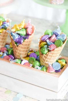 three ice cream cones filled with colorful candies