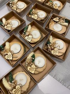 many small boxes with candles in them on a table