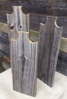 two wooden vases sitting next to each other on a white cloth covered tablecloth