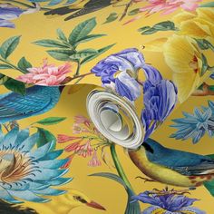 a yellow wallpaper with colorful flowers and birds on it, as well as a roll of tape