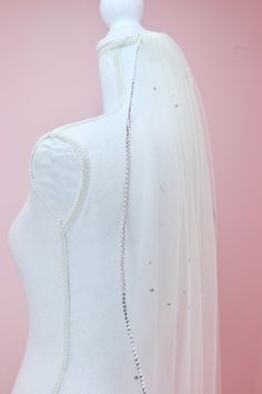 the back of a white veil with beaded beads on it and a necklace attached to it