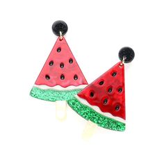 two watermelon slices with black dots and green sprinkles on them