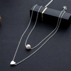 FREE SHIPPING Bohemia Simple fashion Imitation pearl love Heart Double layer Clavicle chain necklace accessories female Jewelry New JKP2835 Elegant White Alloy Charm Necklaces, Trendy Pearl Chain Necklace For Valentine's Day, Elegant White Alloy Charm Necklace, Elegant Alloy Heart Pendant Necklace, Elegant Alloy Necklace For Valentine's Day, Alloy Pearl Necklace With Clavicle Chain As Gift, Pearl Necklace With Clavicle Chain As Gift, Silver Layered Heart Necklace For Gifts, Silver Heart-shaped Layered Necklace For Gifts