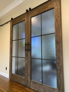 an empty room with glass doors and wood flooring