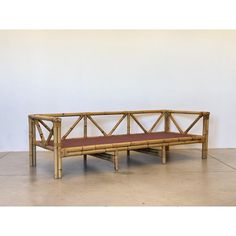 a bench made out of bamboo with a red cushion