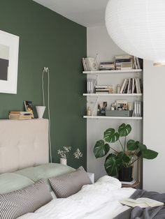 a bed sitting in a bedroom next to a book shelf with books on top of it