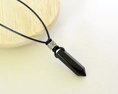 This is a Men's Onyx necklace, Leather stone jewelry, Cool stone necklace, unisex necklace, Onyx choker, adjustable necklace, gift for men. ■ Adjustable length by sliding the knot ■ Material : genuine gemstone, genuine leather (1.5mm Black ), metal beads. Length : 38cm to 71cm (15inches to 28inches) Weight : 7.2g (0.25oz) The details of the gemstone is Onyx point stick 32mm x1, metal beads x1. CumisGems Men's jewelry https://www.etsy.com/shop/CumisGems?section_id=15730953&ref=shopsection_lef Spiritual Black Crystal Necklace With Adjustable Cord, Adjustable Black Crystal Pendant Necklace, Black Crystal Necklace With Adjustable Cord, Black Spiritual Necklace With Adjustable Length, Metal Skull, Necklace Leather, Onyx Necklace, Unisex Necklace, Beaded Skull