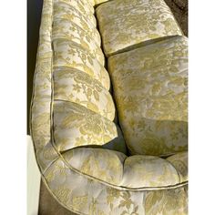 an upholstered couch with yellow and white floral pattern on it's back