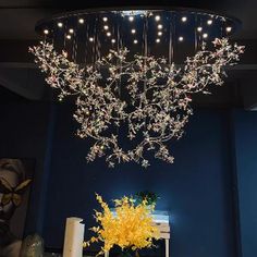 a chandelier hanging from the ceiling in a room with blue walls and yellow flowers