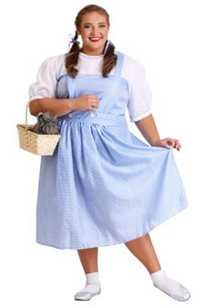 a woman in a blue dress holding a basket and posing for the camera with her hands on her hips