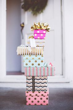 a stack of gift boxes sitting on top of each other in front of a door