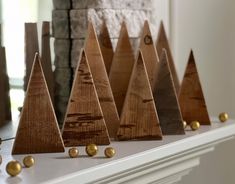 wooden christmas trees lined up on a mantle