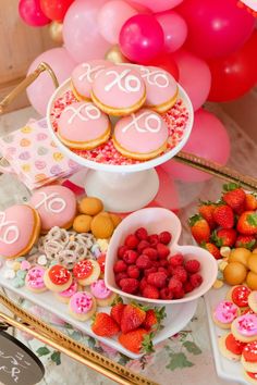 a table topped with lots of desserts and balloons