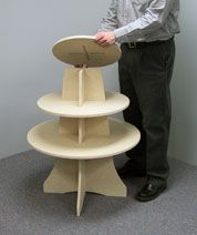 a man standing next to a white table with a shelf on it's side