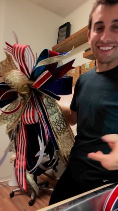 a man standing next to a metal sink in a room with lots of decorations on the wall