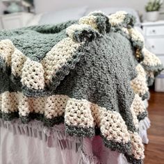 a crocheted blanket sitting on top of a bed