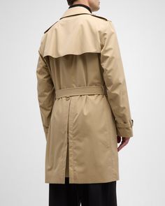 Burberry "Kensington" trench coat made from waterresistant gabardine    Hookandeye collar closure​    Throat latch    Shoulder epaulettes​    Belted waist and cuffs    Side button welt pockets​    Center back vent    Burberry Check lining and undercollar​    Buckles: calf leather    Cotton    Lining: Cotton/viscose    Made in United Kingdom Classic Long Gabardine Raincoat, Classic Business Raincoat For Winter, Classic Winter Business Raincoat, Burberry Kensington Trench Coat, Burberry Suit, Shoulder Epaulettes, Burberry Coat, British Heritage, Burberry Men