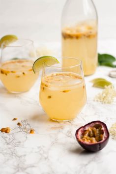 two glasses filled with lemonade and garnished with limes on a marble table