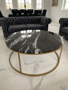 a living room with black couches and marble coffee table