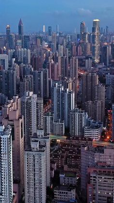 an aerial view of a city at night with skyscrapers and buildings in the foreground