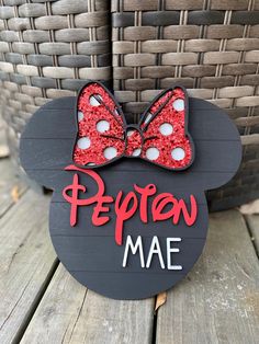 a mickey mouse sign with a red bow on it