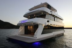 a large white boat floating on top of a body of water at night with lights on it