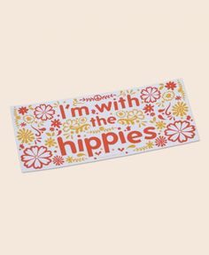 a sticker that says i'm with the hippies in red and yellow flowers