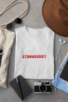 🍓Embrace the fruity vibes with our sweet strawberry short sleeve shirt! Whether you're a fan of strawberry picking, a fruit lover, or just enjoy a pop of color in your wardrobe, this shirt is the perfect choice. ✨Welcome to the Magic Churro Boutique! Creating magic you can wear. ✨ We only create products we'd wear ourselves. If you're looking for fun, funky, retro, or anything in-between, you're in the right place.  👚SIZING & COLORS👚 Please refer to size chart on the listing photos in every listing for a detailed sizing chart with measurements. Since everything is made to order, sizing issues will not be refunded. Colors of the text & design and/or color of the shirts/sweatshirts can vary a little from the photo shown, due to lighting, printing, and/or computer/phone screens. ✈️PROCESSI Cotton T-shirt With Strawberry Print, Cotton Short Sleeve T-shirt With Strawberry Print, White Relaxed Fit T-shirt With Strawberry Print, Trendy Red T-shirt With Strawberry Print, Sweet Red Short Sleeve T-shirt, Sweet Short Sleeve Tops With Fruit Print, Casual White Tops With Fruit Design, Casual White Top With Fruit Design, White Casual Top With Fruit Design