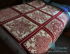 a bed with a red and white quilt on it