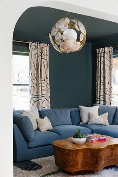 a living room filled with furniture and a wooden table in front of a blue couch