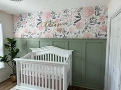 a baby's room with floral wallpaper and white crib