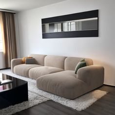 a living room filled with furniture next to a window and a large painting on the wall