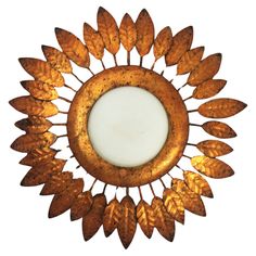 a mirror that has some gold leaves on the front and side of it, with a white background