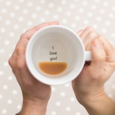 a person holding a coffee mug with the words i love you mum on it