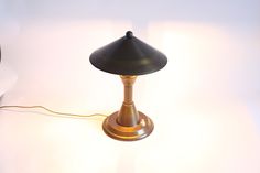 a table lamp sitting on top of a white surface next to a wall mounted clock