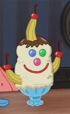 an ice cream sundae with chocolate and bananas on it's head, sitting in front of a computer screen