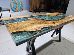 a table made out of wood and metal with blue paint on the top, sitting in a room