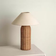 a wicker lamp on a white table