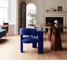 a blue chair sitting in front of a table next to a fire place and fireplace