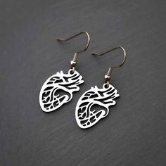 Double the love with these anatomically correct heart earrings! These unique gold or silver colored polished-steel hearts measure about 1" from top to bottom. They dangle delightfully from gold plated or stainless steel hooks and are strong enough to last for years and years. Whether for yourself or someone special (your sweetheart, your mother, or your cardiologist), these earrings are sure to make an impression. Perfect for: Nurses, doctors & medical students Friends, lovers Anyone with a hear Anatomically Correct Heart, Real Heart, Anatomical Heart, Medical Students, Heart Jewelry, Minimalist Earrings, Heart Earrings, Gift Shop, Gold Earrings