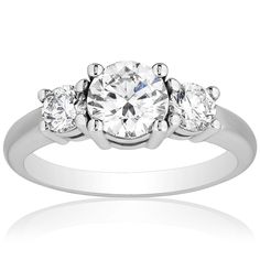 When you see this 1.50 carat total weight diamond ring you will immediately be enchanted by its timeless elegance and beauty. Set in finely crafted 18 karat white gold, this diamond ring features a .70 carat center diamond and is complimented by two .40 carat round shaped diamonds on each side. We know the quality of your diamond ring is important and therefore, it is authenticated and accompanied by an IGI certificate. Diamond Three Stone Ring, Three Stone Diamond Ring, Stone Diamond Ring, Three Stone Diamond, Three Stone Ring, Three Stone Rings, Three Stone, Jewelry Store, Stone Rings