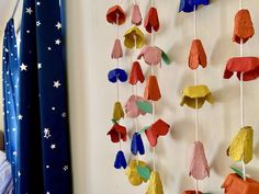 a child's room with colorful paper mobiles hanging from the wall and stars on the curtains