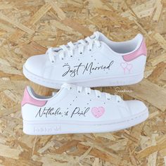 two white shoes with pink hearts and the words best married written on them are sitting on wood chips