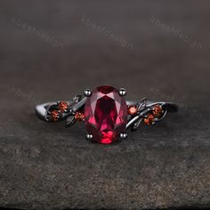 a ring with a large red stone surrounded by garnets