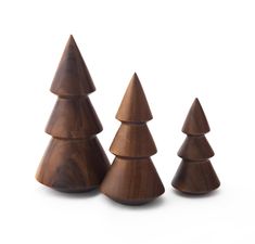 three wooden christmas trees on a white background