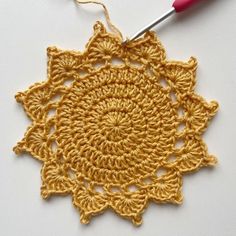 a crocheted doily with a red hook